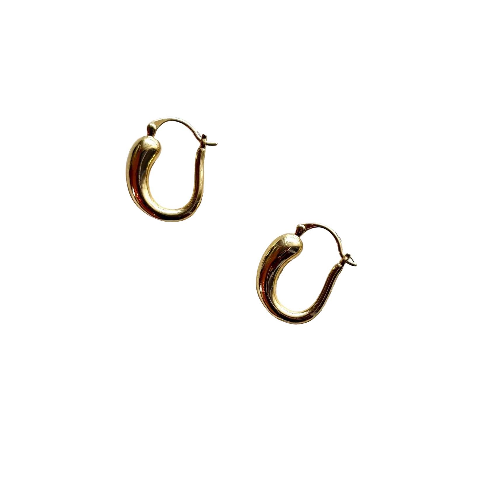 Gold hoop earrings on a textured wooden surface-iris 1956 jewelry